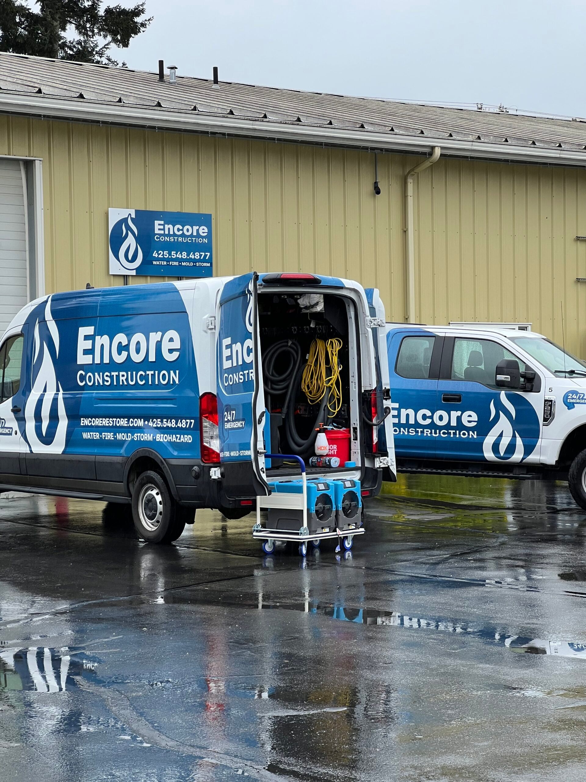 Encore Construction vans carrying drying equipment outside the restoration facility
