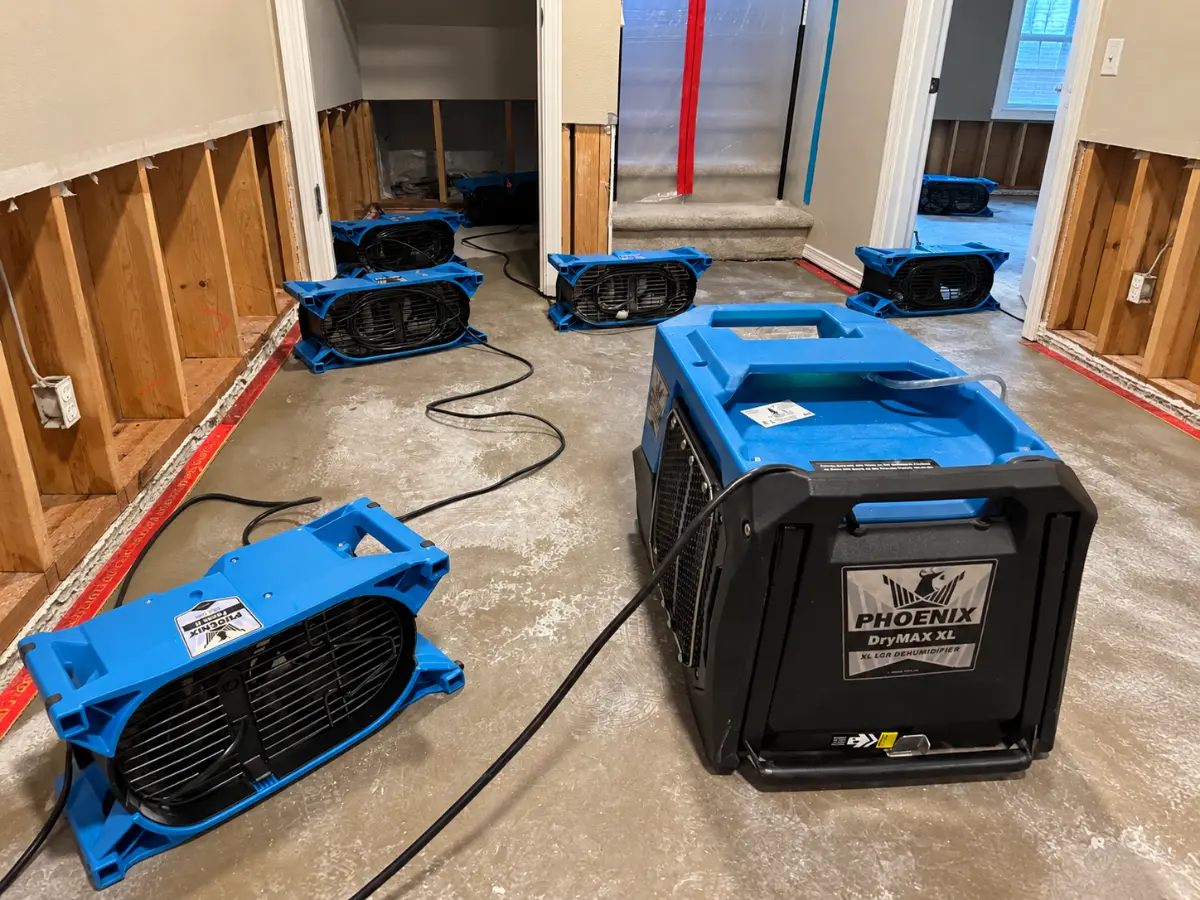 Air movers and dehumidifier drying a residential interior after water damage.